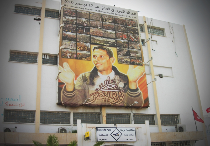 2010年12月17日自焚的青年布阿濟吉（Mohamed Bouazizi），卒年26歲。他的頭像高掛在突尼西亞中部城市Sidi Bouzid的街頭。布阿濟吉的死亡引爆了翌年年初的茉莉花革命。