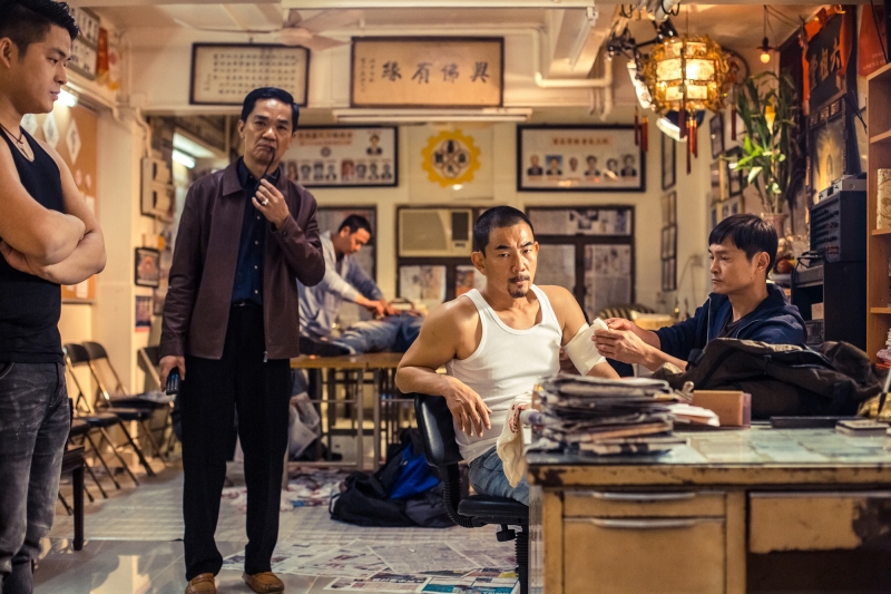《樹大招風》改編97回歸前的香港三大賊王真人真事，劇照為任賢齊飾演的悍匪葉國歡與同夥搶珠寶行後，後與銷贓商人談判。